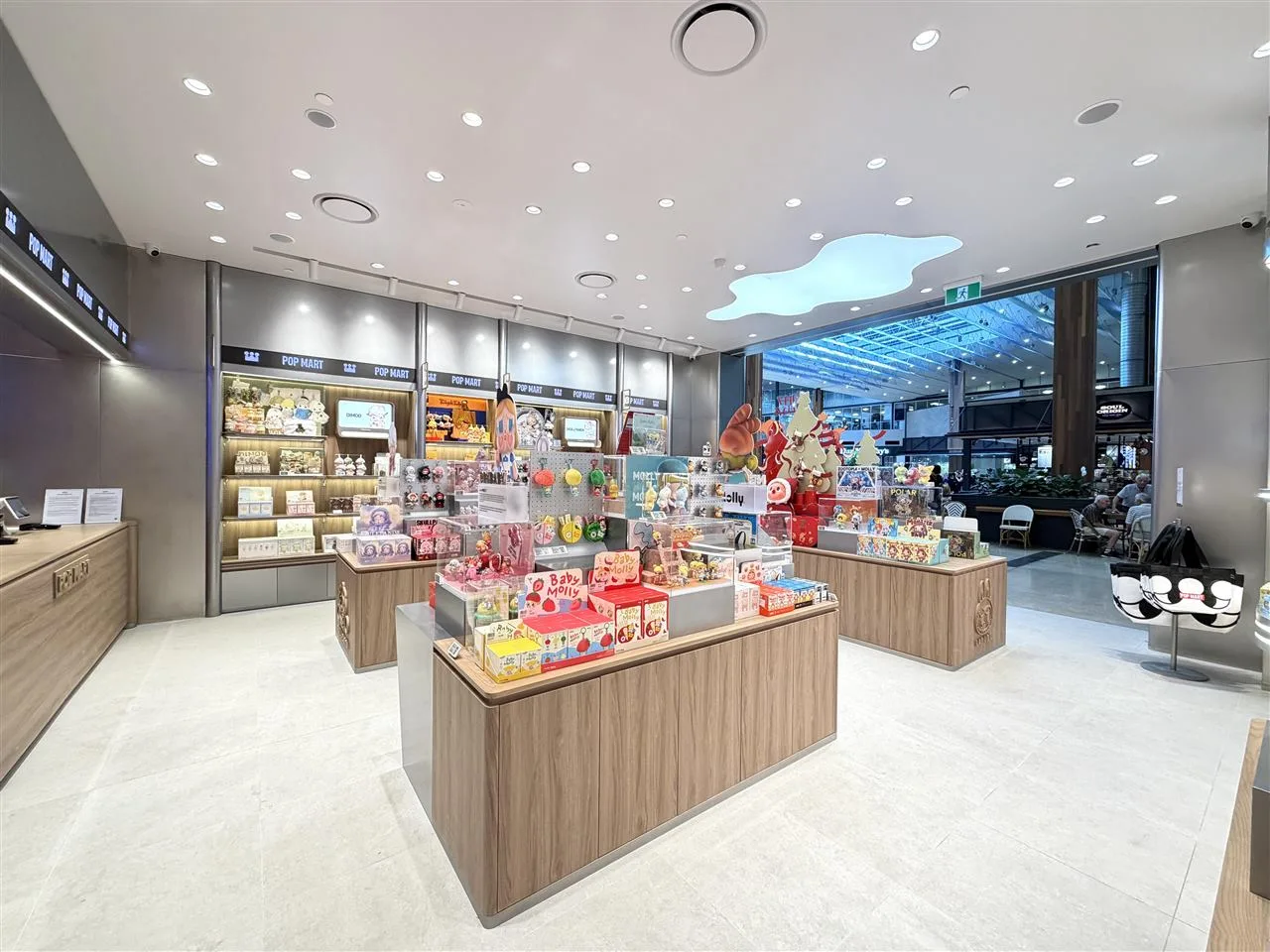 Pale Toy Storefront with Broad Illuminated Fascia — reference view 6 of 8